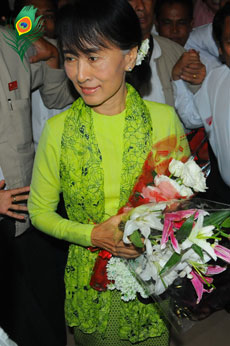 urma democracy leader Aung San Suu Kyi holds a bouquet of flowers as she walks through the international airport in Rangoon on Sunday, Sept. 16, 2012. She is expected to arrive in Washington on Monday, where she will receive the US Congressional Gold Medal and speak to various groups, followed by events in  New York City, Fort Wayne, the San Francisco Bay area, Los Angeles and other locations. Photo: Hein Htet / Mizzima