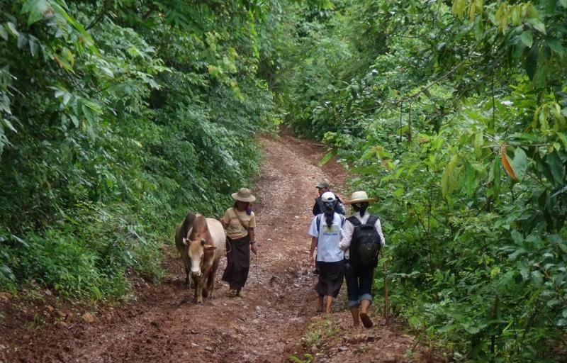 Maw Kayah and development workers are traveling on the slope of mountain