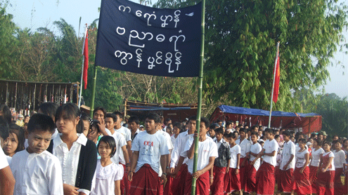 More than 1,000, many people dressed in traditional red and white colors, holding banner, attended the Mon National Day celebration.