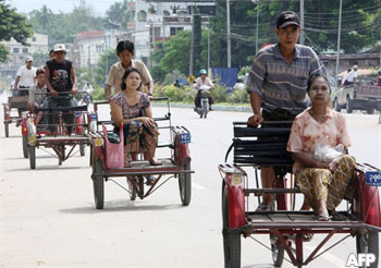 Villagers ride on three-wheel vehicles at a market area in Myawaddy, Burma, in this file photo. Normally, Thai and Burmese goods move daily over the Friendship Bridge linking the two countries. However, Burmese customs banned imports on Wednesday, the latest in a series of closures. AFP PHOTO/Pornchai KITTIWONGSAKUL