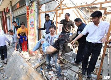 A man carries the body of a woman who was killed after a 5.4-magnitude earthquake hit Yingjiang County in southwest China's Yunnan Province on March 10, 2011. Unofficially, at least 19 people were killed and 174 others injured in the earthquake that struck a remote area of southwest China near the border with Burma, officials said. AFP PHOTO