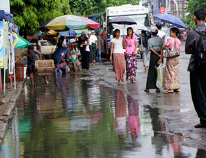 ရန်ကုုန်မြို့တွင် စနေနေ့ မတ်လ ၁၂ ရက်၊ ၂၀၁၁ ခုုနှစ်က မိုုးရွာသွန်းမှုဖြစ်ပွားနေစဉ် မြို့လယ်ဘတ်စ်ကားမှတ်တိုုင်တခုုတွင် စောင့်ဆိုုင်းနေကြသော ခရီးသည်များ။ ဓာတ်ပုံု- မဇ္ဈိမ။ ရန်ကုန်တိုင်း ခရမ်း၊ ဒဂုံုမြို့သစ်တောင်ပိုုင်းနှင့် ဒဂုံုဆိပ်ကမ်းမြို့နယ်များတွင် သောကြာနေ့ မွန်းလွဲပိုင်းတွင် လေပြင်းတိုက်ခဲ့ရာ နေအိမ် ၁၅၀ ခန့် ပြိုကျပြီး၊ လူပေါင်း ရ၆၀ လေဘေးဒုုက္ခသည်ဖြစ်သွားသည်။