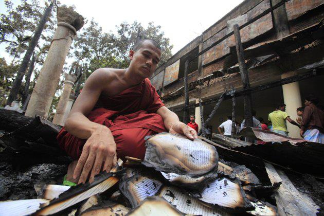 A-Bangladeshi-Buddhist-Monk-reacts-as-he-looks-at-a-burned-book-shelf-at-a-Buddhist-temple-on-Oct.-1-2012