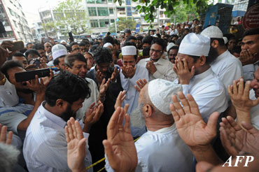 A group of Muslim people pray for the victims of a fire at an Islamic school in Yangon on April 2, 2013. (AFP)