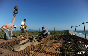 Construction laborers working on an elevated platform at a deep-sea port project in Mayingyi, part of the Dawei Special Economic Zone development. (AFP PHOTO)