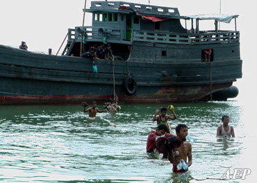 This picture taken on December 30, 2012, shows Rohingya boatpeople from Burma disembarking at a beach on Langkawi island in Malaysia. About 500 Rohingyas were forced to swim the last 500 meters to the shore at the end of a 15-day boat journey. (AFP)