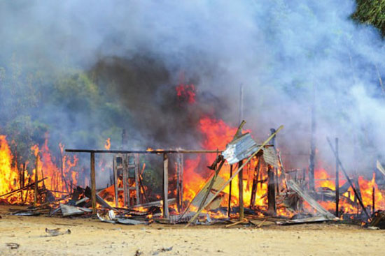 A house near Laiza, Kachin State burns after being bombed by the Burma army in December 2012.  The conflict that has lasted nearly two years has displaced an estimated 100,000 refugees, who are now vulnerable to a growing human trafficking ring - Photo by RANIA