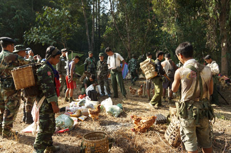 အပစ်ခတ်ရပ်စဲရေး ပြီးနောက် KNPP နှင့် အစိုးရတပ်တို့ နယ်စပ်တနေရာတွင် အတူတကွ စျေးဝယ်နေကြစဉ် (ဓါတ်ပုံ-ကေတီ)