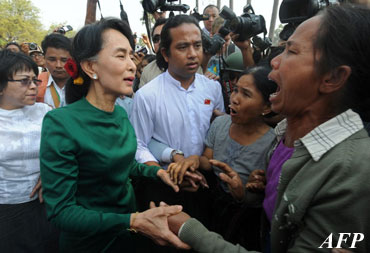 Myanmar democracy leader Aung San Suu Kyi (L) speaks with locals during her visit at a village near the Chinese-backed copper mine project, in Monywa northern Myanmar on March 14, 2013. Suu Kyi urged protesters to accept a controversial Chinese-backed mine that was the scene of a violent crackdown last year, or risk hurting the economy. AFP PHOTO