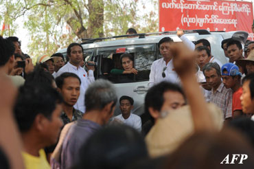 Aung San Suu Kyi watches out from her car as people protest against the Latpadaung copper mine project on March 14, 2013. AFP PHOTO