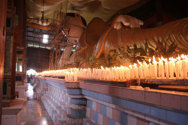 The participants are lighting candles in front of Buddha image on the day.