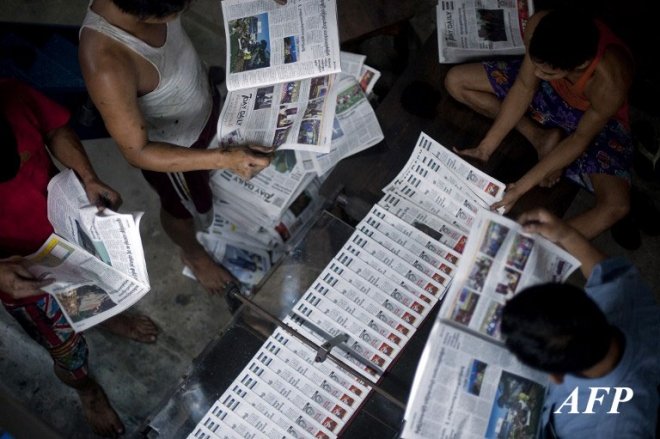 Workers check copies of a daily newspaper at a printing house in Yangon early on September 6, 2013. Privately owned daily newspapers have been available since April 1 in Myanmar under new freedoms that represent a revolution for a media industry which was shackled under military rule. AFP PHOTO