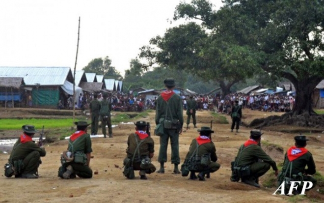 myanmar security personnel warily observe a mob