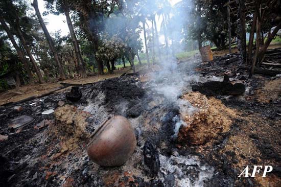 Smoke rises from the remains of burnt properties in Pauk Taw Wa village near Thandwe, in Myanmar's western Rakhine state on October 2, 2013. Terrified women and children hid in forests and security forces patrolled tense villages in western Myanmar on October 2 as police said the toll from fresh anti-Muslim unrest rose to five. AFP PHOTO