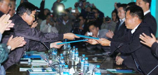 RCSS/SSA head of delegation Pawng Kherh exchanging signed copy of agreement with Naypyitaw representative U Aung Min, 16 January 2012. (Photo: taifreedom.net)