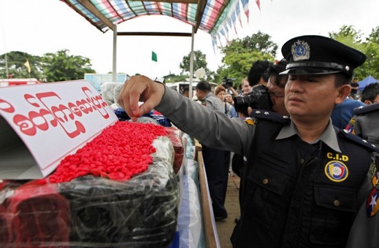 A Myanmar policeman checks a pile of drugs prior to a 'Destruction Ceremony of Seized Narcotic Drugs' to mark International Day against Drug Abuse, in Yangon, Myanmar, 26 June 2014. Myanmar authorities destroyed drugs worth some 138.17 million US dollar during incinerations in Yangon, Mandalay and Taunggyi. EPA/LYNN BO BO