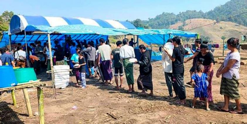 People fleeing due to fighting between the military and the Karen National Union (KNU) line up to receive food at a temporary lodging for internally displaced people (IDPs) in Karen state. Photo: AFP