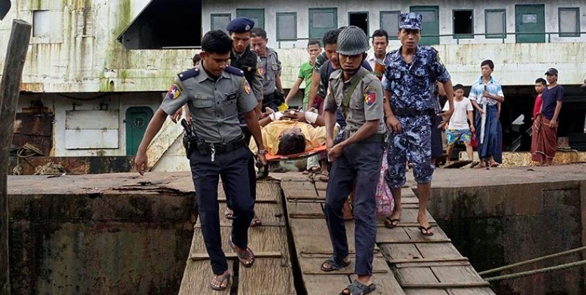 Myanmar policemen carry an injured border guard police (C) as he arrives to the Sittwe port, Sittwe, Rakhine State, western Myanmar, 26 August 2017. Photo: Nyunt WIn/EPA