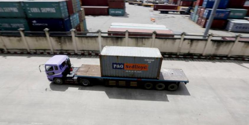 A truck carries a container at the Ahlone international terminal port in Yangon. Photo: EPA