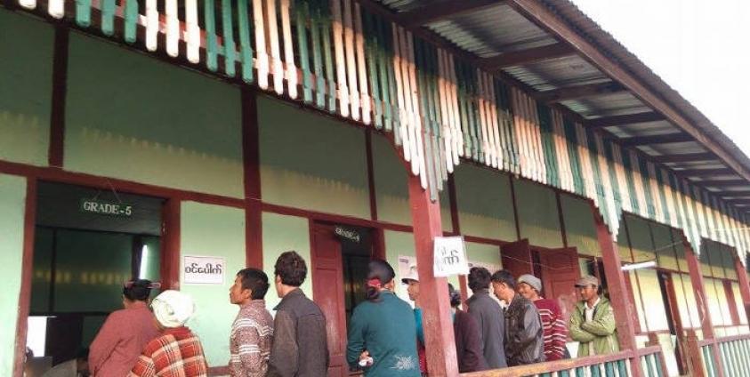 People stands in line at the polling station in Pyun Thone Lone Village of Kachin Sate's Mogaung Township to cast their votes on the Election Day