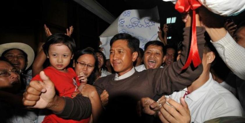 This file photo taken on January 13, 2012 shows Kyaw Min Yu (C), known as Jimmy, and his wife Ni Lar Thein (L) holding her child, both members of the 88 Generation student group, celebrating upon their arrival at Yangon international airport following their release from detention. Photo: AFP