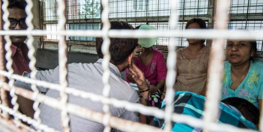 (File) Six detained Myanmar family members facing charges of human trafficking are transported in a prison van following their trial in Yangon on October 13, 2016. Photo: AFP