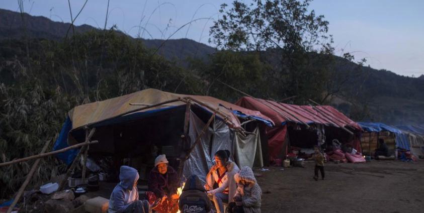 This photo is taken on January 21, 2017 shows a refugee family in front of their temporary shelter near Lung Byeng village, Waimaw township in Kachin state. Photo: Hkun Lat/AFP