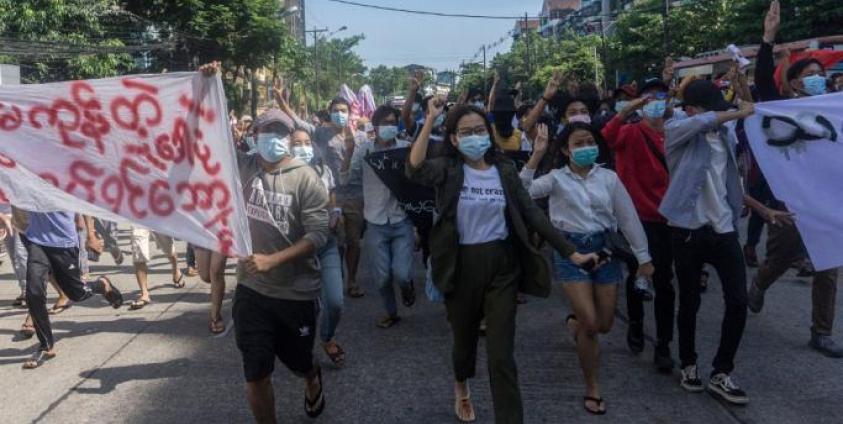 Photo: Protesters hold up banners and the three-finger salute during a demonstration against the military coup in Yangon on May 14, 2021. Photo: AFP