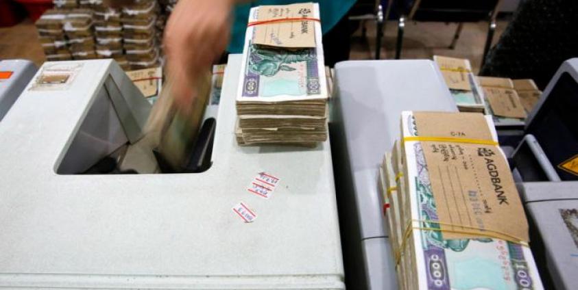 Staff members of the Asia Green Development Bank count Myanmar Kyat notes with machines at Sule branch office, in Yangon, Myanmar, 14 December 2016. Photo: EPA