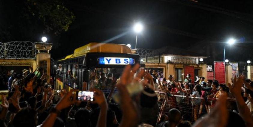 Newly-released prisoners wave from a bus as they depart the Insein Prison in Yangon on October 18, 2021, after authorities announced more than 5,000 people jailed for protesting against a February coup which ousted the civilian government would be released. AFP