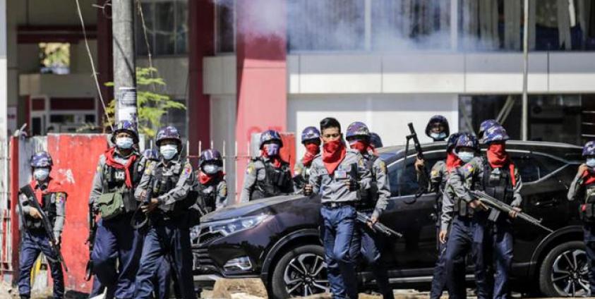 Anti-riot police officers prepare to fire tear gas as they try to disperse protesters during an anti-coup protest following the military crackdown in Yangon. Photo: EPA