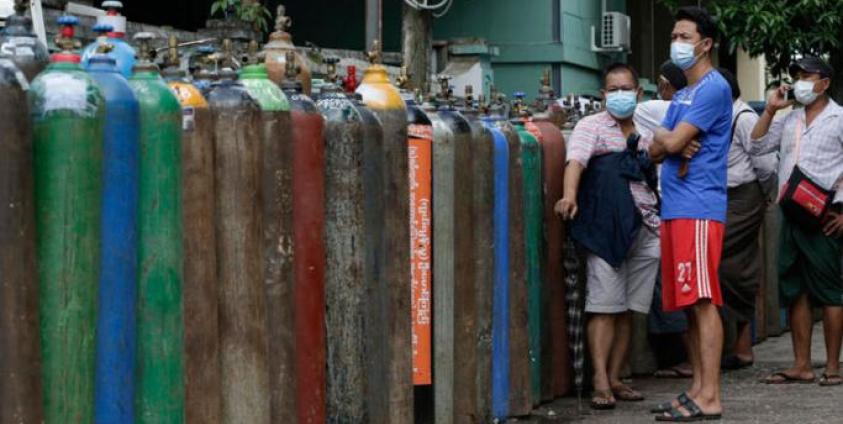 Myanmar people wait near oxygen tanks lined up to refill outside an oxygen factory in Yangon, Myanmar, 11 July 2021.  Photo: EPA