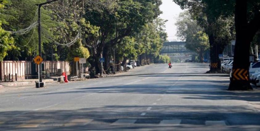 A woman crosses the empty street in downtown Yangon, Myanmar, 10 December 2021. Photo: EPA