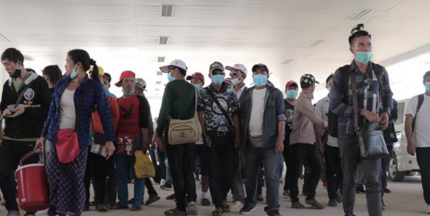 Myanmar nationals wearing facemasks amid concerns over the spread of the COVID-19 coronavirus walk at the immigration post in Myawaddy near the Thai border on March 23, 2020, as thousands of people crossed from Thailand as the border crossings were due to close because of the growing pandemic. Photo: AFP