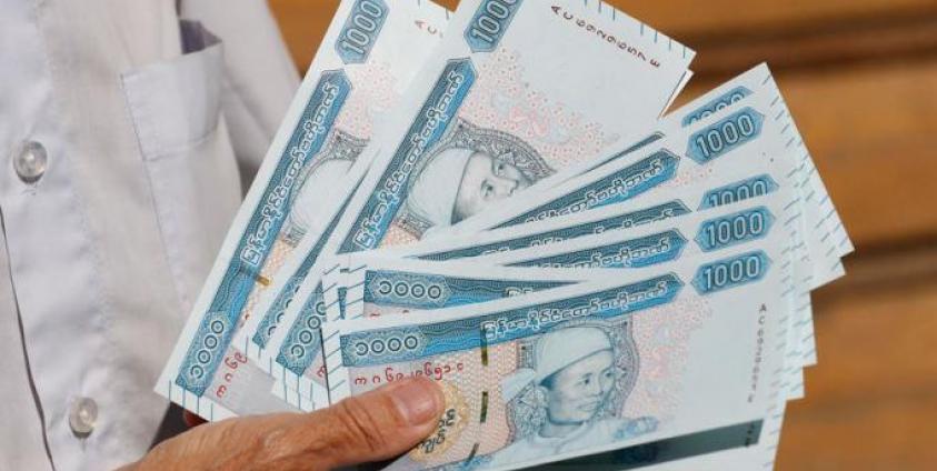 A man holds new edition of 1,000 Myanmar Kyats banknotes featuring portrait of late General Aung San outside the Myanmar Economic Bank in Yangon, Myanmar, 07 January 2020. Photo: Nyein Chan Naing/EPA