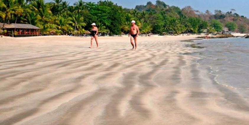 Foreign tourists walk along Ngapali beach, on the Bay of Bengal, west coast of Myanmar. Photo: EPA