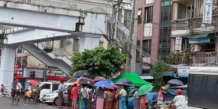 People queue to buy medicine at a pharmacy in Yangon. (Photo: CJ)