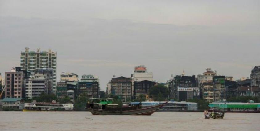 Residential and commercial buildings by the river banks as boats sail across the Yangon River. Photo: Sai Aung Main/AFP