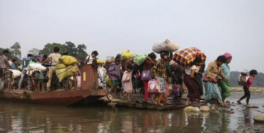 This picture taken on April 26, 2018 shows displaced Kachin residents crossing Malikha river on a ferry to escape the fighting in Injanyan village near Myitkyina between the Kachin Independence Army, ethnic armed group against the Myanmar government troops in Myanmar's northernmost state of Kachin near the border with China. Photo: Zau Ring Hpra/AFP