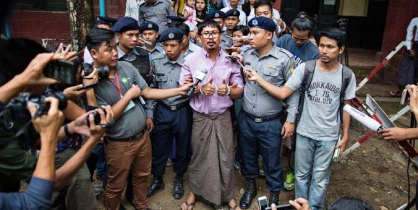 (File) Detained Reuters journalist Wa Lone (C) talks to media while being escorted by police as he leaves the court after his trial hearing in Yangon, Myanmar, 02 July 2018. Photo: Lynn Bo Bo/EPA