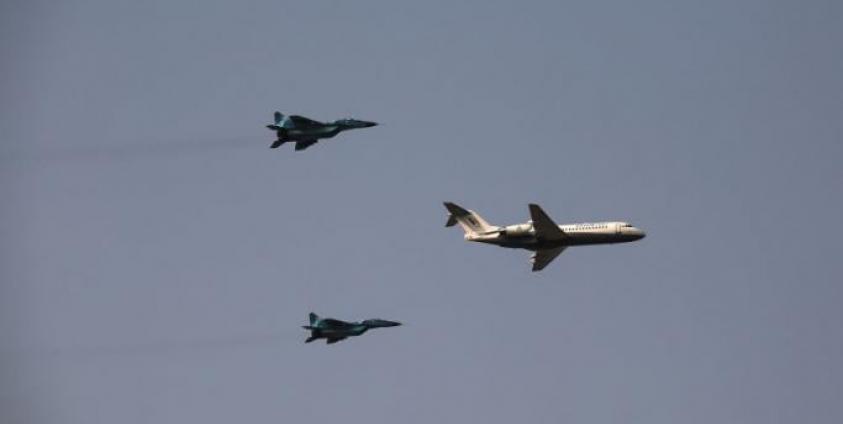 Myanmar Air Force fighter jets accompany an airplane during a display to celebrate Myanmar's 77th Armed Forces Day in Naypyidaw on March 27, 2022.Photo by AFP