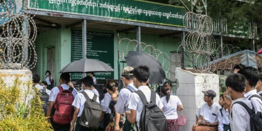 Students wait at a school entrance in Sittwe, capital of western Rakhine State on June 1, 2021. Schools in Myanmar opened on June 1 for the first time since the military seized power, but teachers and students are set to defy the junta's calls for full classrooms in a show of resistance. Photo: AFP