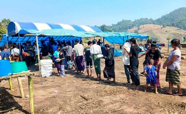 People fleeing due to fighting between the military and the Karen National Union (KNU) line up to receive food at a temporary lodging for internally displaced people (IDPs) in Karen state. Photo: AFP