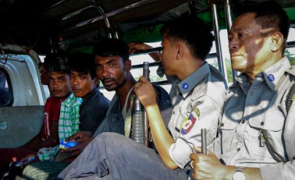 (File) Rohingya men escorted by armed policemen sit in a light truck at the KyaukTan township, south of Yangon, Myanmar, 16 November 2018. Photo: EPA