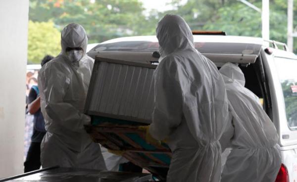 Members of Yangon Free Funeral Service Society (FFSS) wearing protective clothes carry the coffin of a person who has died from influenza A (H1N1) arrives at a cemetery in Yangon, Myanmar, 22 June 2019. Photo: Nyein Chan Naing/EPA