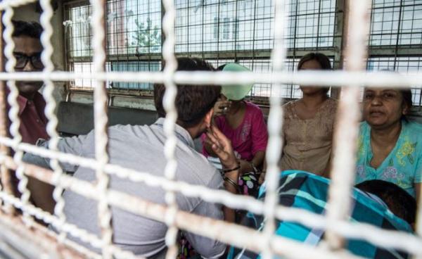 (File) Six detained Myanmar family members facing charges of human trafficking are transported in a prison van following their trial in Yangon on October 13, 2016. Photo: AFP