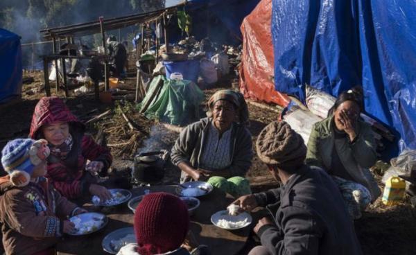 A Kachin refugee family eating near Lung Byeng village in Waimaw township in Kachin state. Photo: Hkun Lat/AFP