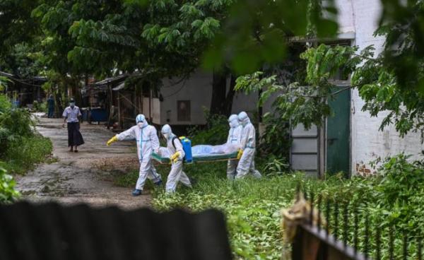 Volunteers wearing personal protective equipment (PPE) carry the body of a victim of the Covid-19 coronavirus to a cemetery in Hlegu Township in Yangon on July 10, 2021. Photo: AFP