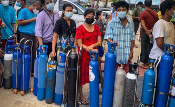 This picture taken on July 14, 2021 shows people waiting to fill empty oxygen canisters at a location donating oxygen at no cost in Yangon, amid a surge in the number of Covid-19 coronavirus cases. Photo: AFP