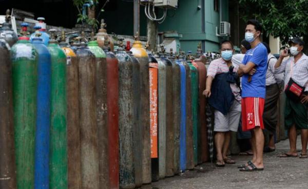 Myanmar people wait near oxygen tanks lined up to refill outside an oxygen factory in Yangon, Myanmar, 11 July 2021.  Photo: EPA